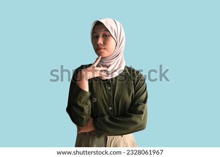 Confused worker woman wearing hijab and dark green army shirt have thinking gesture.