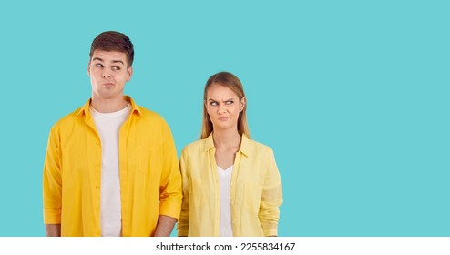 Confused young Caucasian man and woman looking to side with funny dissatisfied face doubting something to be near place for inscription dressed in casual clothes stands in turquoise studio - Shutterstock ID 2255834167