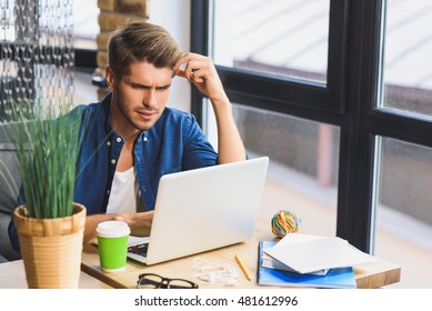 Confused Young Freelancer In Front Of A Laptop