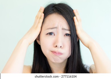 confused young woman against light green background