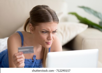 Confused young woman having problem with blocked credit card making rejected unsecure online payment using laptop at home, invalid expired account, transaction failed, money withdraw impossible, debt
