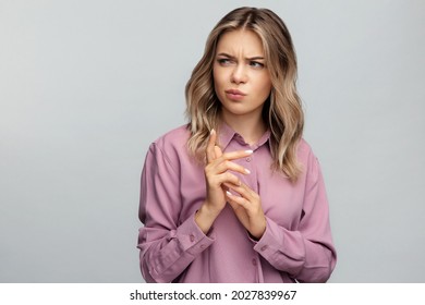 Confused Young Woman Looking Aside With Skeptical And Suspicious Emotion Thoughtful And Pensive Bending Fingers While Making Decision. Portrait Of Sarcastic Doubtful Female Isolated At Studio Wall