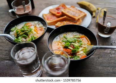 Congee With Minced Pork And Slices Of Bread And Delicious Strawberry Jam Is A Favorite Breakfast For Thai People. On Wood Table Texture.