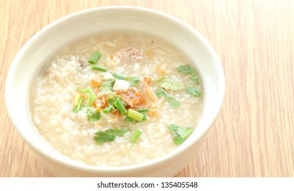 Congee Round Bowl On Wood Texture Tile Floor.