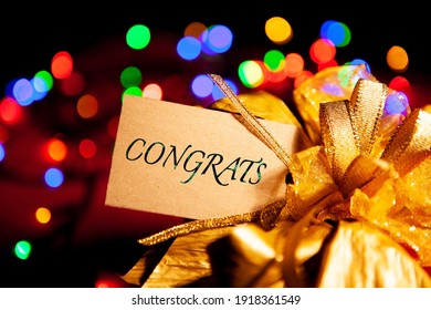 Congrats - Text On A Gift Box Label With A Large Gold Bow. 