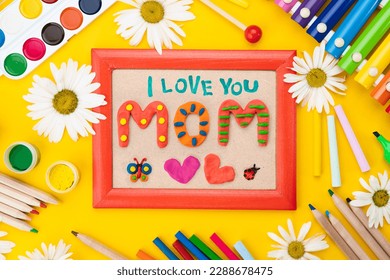 Congratulations from a child on Mother's Day. Bright hand drawn childish card with crafted plasticine colorful mom lettering, butterfly. Flat lay children's creative handmade multicolor Modeling Clay - Powered by Shutterstock