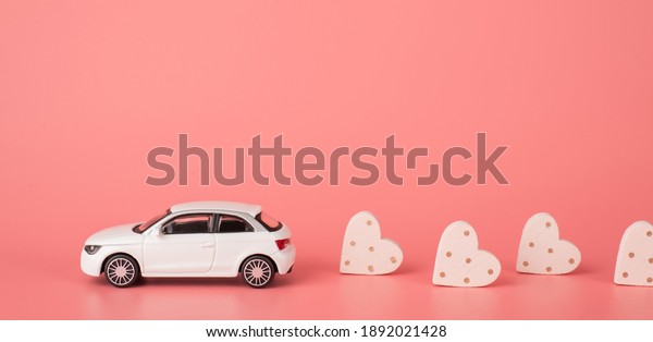 Congratulations\
on st valentine day concept. Side profile close up view photo of\
mini modern car riding and leaving behind small hearts isolated\
light tone backdrop with place for\
header