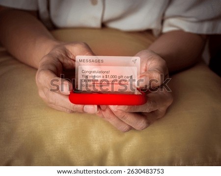 Congratulations, you won, malware scam sms, fake message phishing from scammer concept. Spam text, winning prize money with link tracking, alert display on mobile phone screen in elderly female hand.