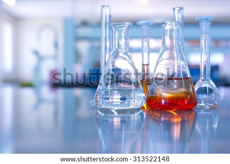 conical flask glassware with orange solution in chemical science laboratory in school or university technology background 