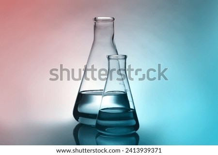 Conical flasks with liquid on table. Color toned