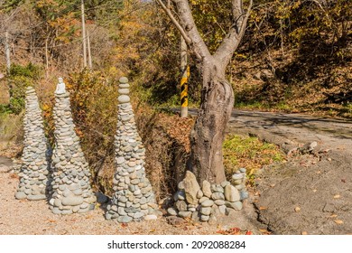 Conical Rock Towers In Gravel Lot Beside Rural Country Road.