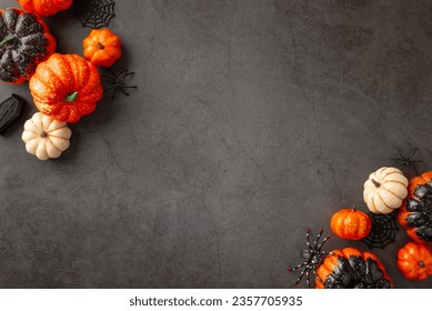 Conjuring Halloween vibes. Top view shot of themed setup - pumpkins, eerie spiders, cobweb and coffin, against dark, textured backdrop. Expansive area for text or promo - Powered by Shutterstock