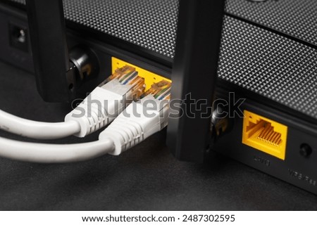 Connect an Ethernet Cable to a Wireless Router on dark. Ethernet, rj45 and electric cables, connected to router. Network concept
