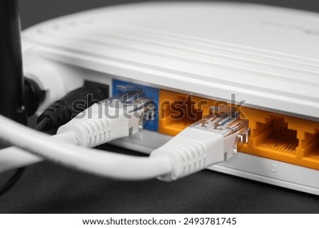 Connect an Ethernet Cable to a Wireless Router on dark. Ethernet, rj45 and electric cables, connected to router. Network concept
