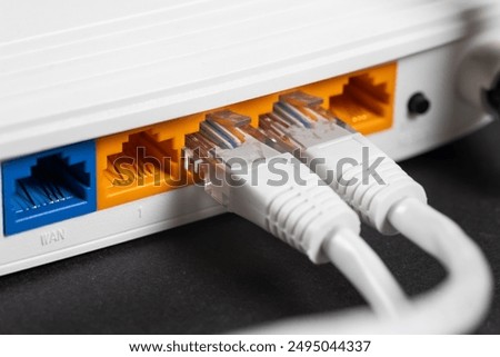 Connect an Ethernet Cable to a Wireless Router on dark. Ethernet, rj45 and electric cables, connected to router. Network concept