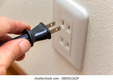 Connect the power plug to the electric outlet on the wall - Shutterstock ID 2003511629