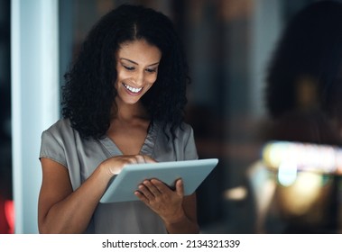 Connected Around The Clock. Shot Of A Young Businesswoman Using A Digital Tablet During A Late Night At Work.