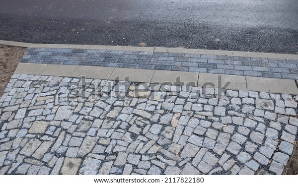 connecting the park path and sidewalk to the asphalt\
road using a strip of concrete blocks with protrusions for the\
blind. they know where the sidewalk ends with the mass of feet.\
drainage tiles soak 