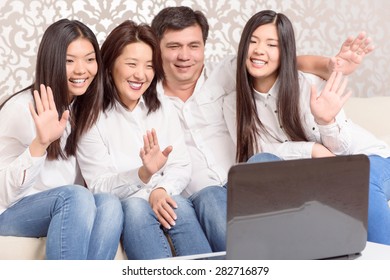 Connecting People. Asian Family Chatting On Skype At Home