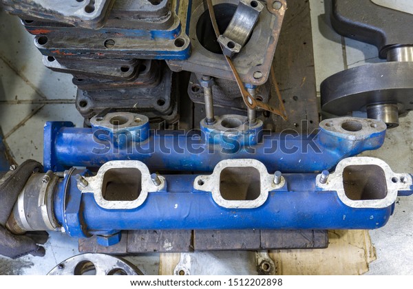 The connecting rod, piston\
and cylinder block in a disassembled condition in a car\
workshop.