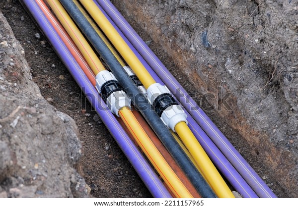 connecting underground electric cable infrastructure\
installation. Construction site with A lot of communication Cables\
protected in tubes. high speed Internet Network cables are buried\
