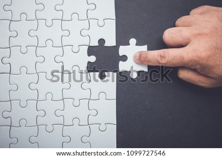 Connection concept : Hand holding pieces of jigsaw puzzle and insert into the missing hole Foto d'archivio © 