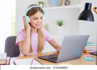Connection is good i can here you. Little kid girl sit comfort cozy table desk study remote use laptop online teacher communication chatting have headset in house indoors