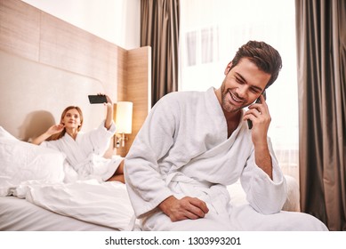 Connection With Relatives. Couple Are Lying In Hotel Room Bed