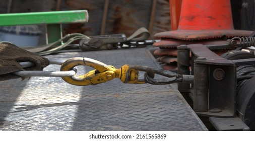 Connection of a tow truck winch to the cable attached to an automobile.