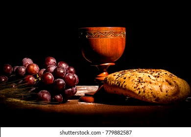 consecration cup with bread and grapes on the table