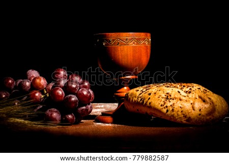consecration cup with bread and grapes on the table