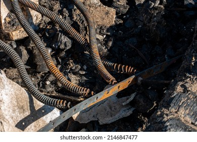 The Consequences Of A Fire In An Old Wooden Country House. Ashes And Burnt Boards Close-up. A Fire In A Residential Wooden House Due To Arson Of Dry Grass.