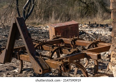 The Consequences Of A Fire In An Old Wooden Country House. Ashes And Burnt Boards Close-up. A Fire In A Residential Wooden House Due To Arson Of Dry Grass.