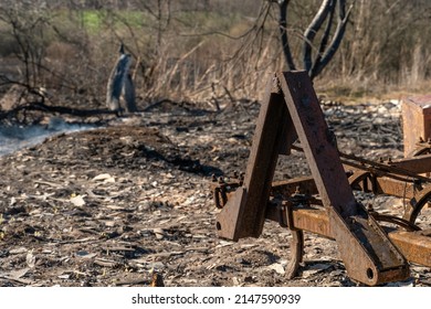 The Consequences Of A Fire In An Old Wooden Country House. Ashes And Burnt Boards Close-up. A Fire In A Residential Wooden House Due To Arson Of Dry Grass.