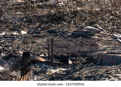 The Consequences Of A Fire In An Old Wooden Country House. Ashes And Burnt Boards Close-up. A Fire In A Residential Wooden House Due To Arson Of Dry Grass.