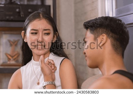 A conservative young asian woman retreats, unwilling to give her lustful boyfriend a lurid kiss. Feeling repulsed by his inappropriately horny behavior.