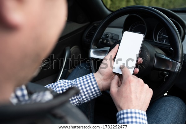Considering the next step. Middle-aged man\
working using phone while sitting in the\
car.