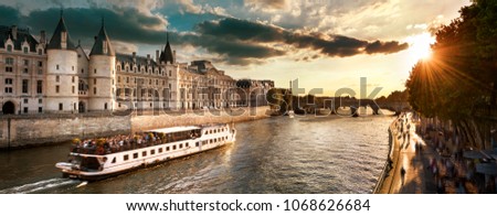 Consiergerie, Pont Neuf and Seine river with tour boat at sunny summer sunset, Paris, France