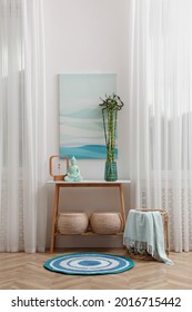 Console table with bamboo and Buddha statue near light wall indoors. Interior design