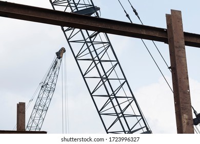 Consruction work with large steel structure and industrial cranes against a semi blue sky

