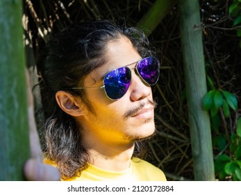 Constantia, Cape Town, South Africa 05-02-2022

Man Wearing Purple Tinted Sunglasses, Standing Under A Vine Covered Walkway. Sunlight Shining On His Face.