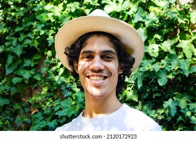 Constantia, Cape Town, South Africa 05-02-2022

Handsome Man Wearing A Summer Hat. Man Is Smiling. Spots Of Sunlight Shining On His Face Through The Tree Leaves Above. Vines And Leaves In Background.