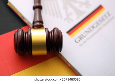 The constitution basic law book of Germany and judge hammer lies on Gremany flag background close up