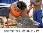 Constriction worker making concrete in an orange mixer