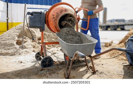 Constriction worker making concrete in an orange mixer