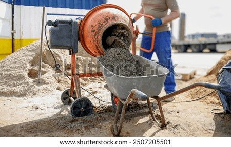 Constriction worker making concrete in an orange mixer