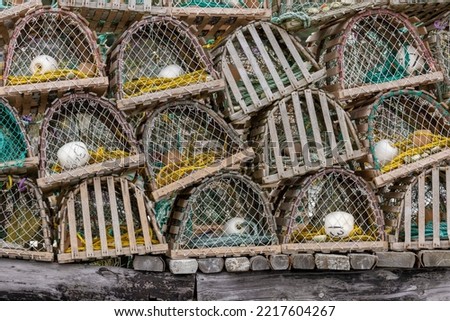 Constructed of wood and netting, these lobster pots, or traps, are stacked for storage while the lobster fishing season is closed. They were used for generations but are being replaced by wire traps.