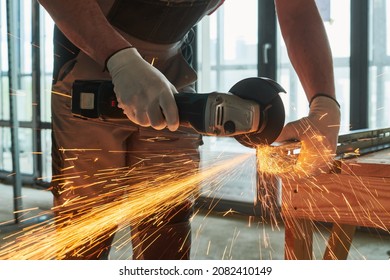 Constructiion work. Worker use angle grinder for metal cutting with sparks