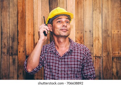 construction architect man working using walkie-talkie transmitter Handheld radio communication technology and people concept Copy Space On the wooden wall