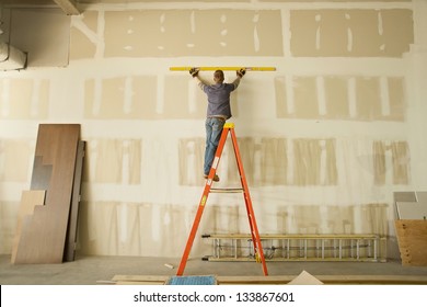 Construction Area With Man Working On Ladder